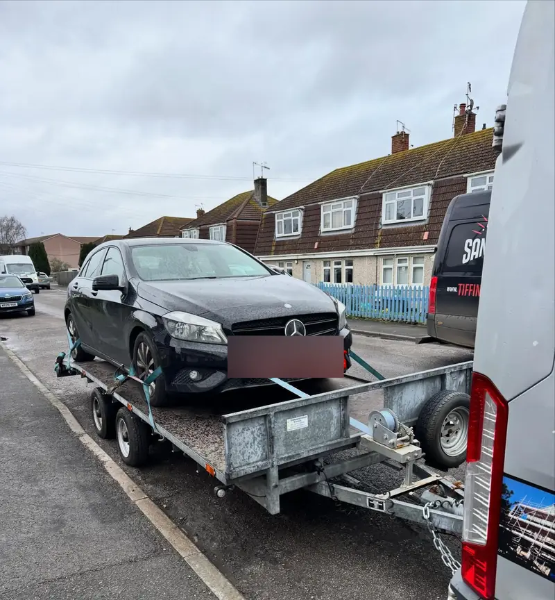 Black Mercedes A-Class strapped onto a trailer